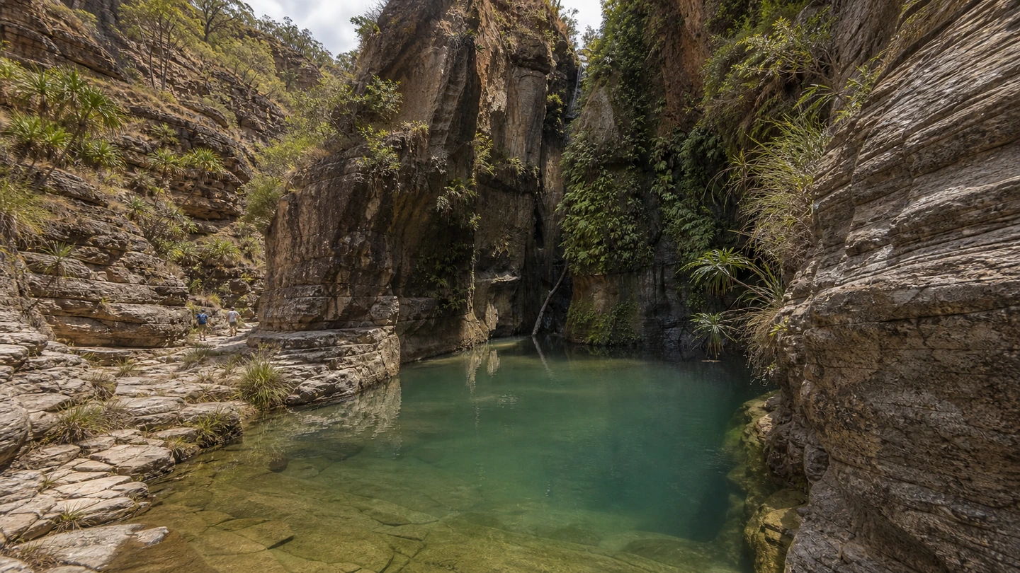 Natural pool and hikers among sandstone cliffs in Isalo National Park